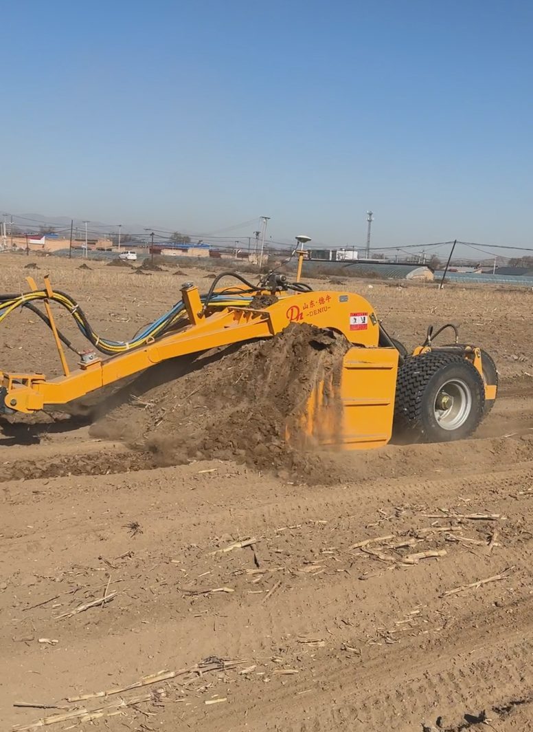 Leveler blade lifting a mound of soil