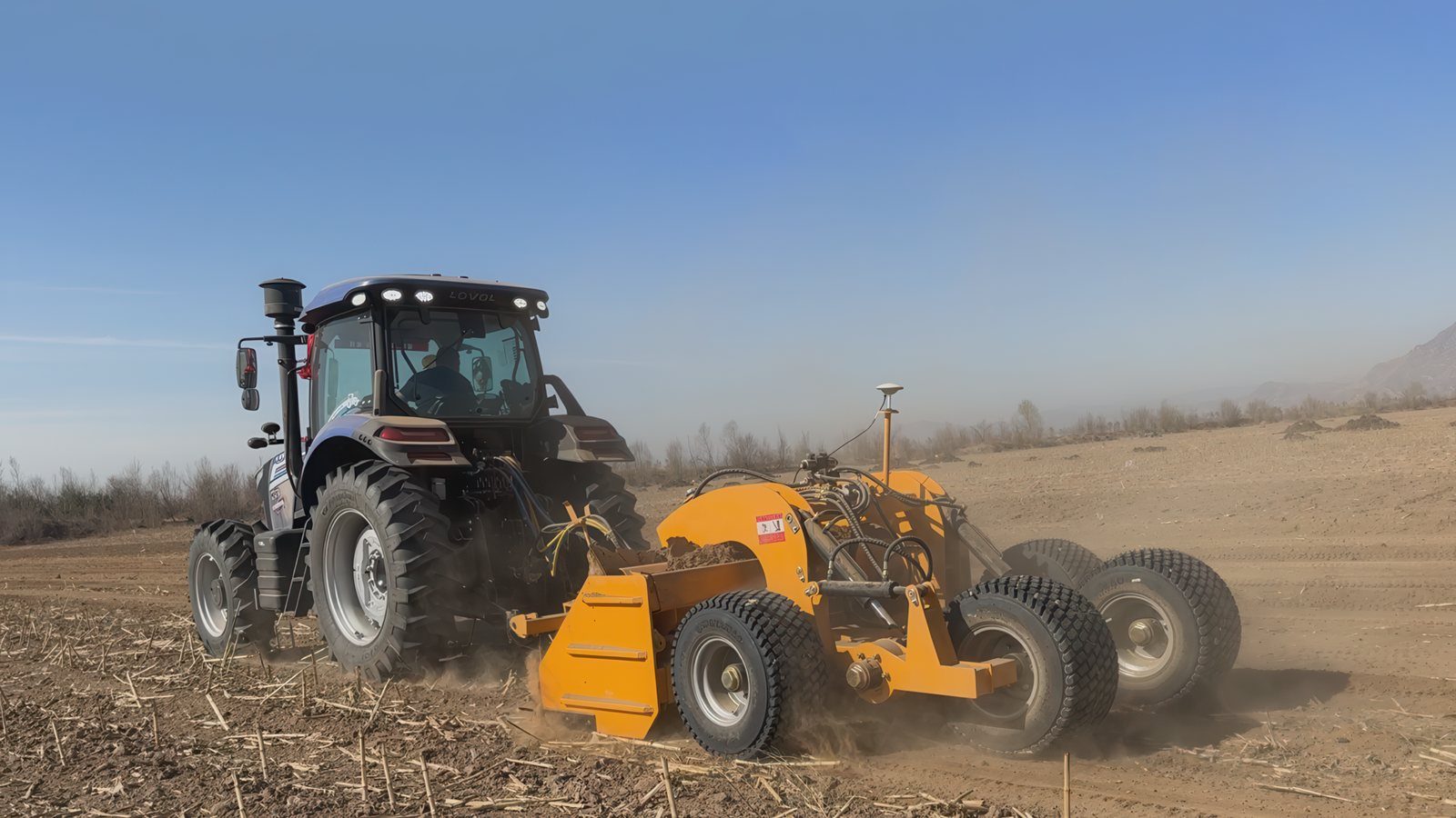 Tractor-towed hydraulic land leveler with GPS RTK antenna working in the field